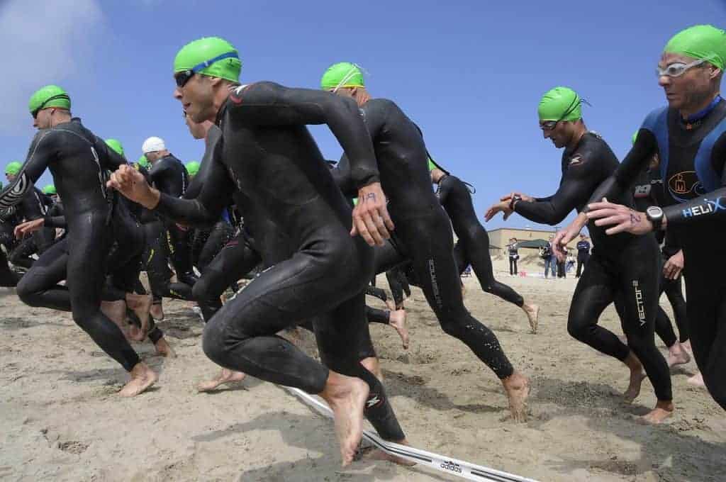 triathloniści biegnący do wody