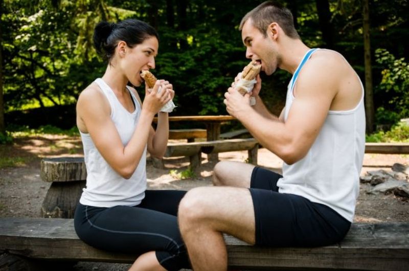 Węglowodany w diecie sportowca - para sportowców jedząca kanapki