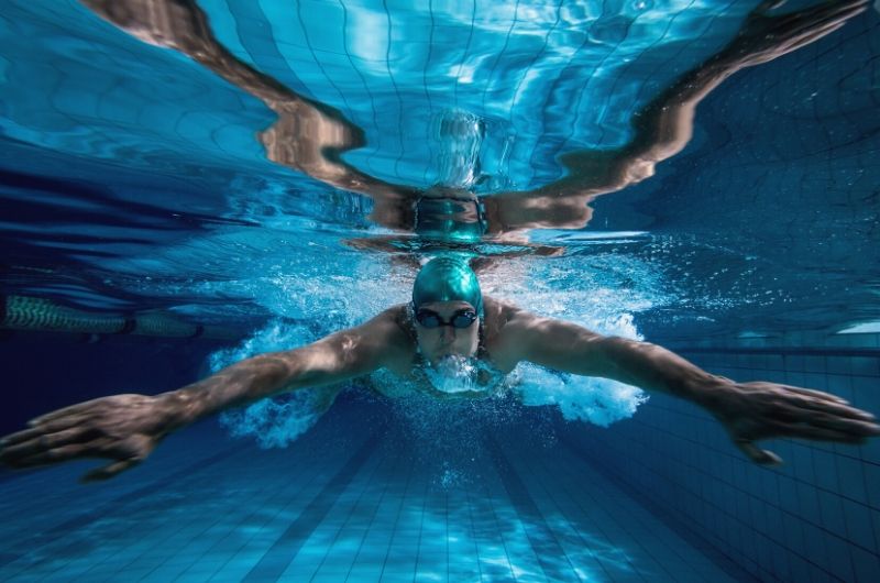 Styl klasyczny - mężczyzna pływający w basenie